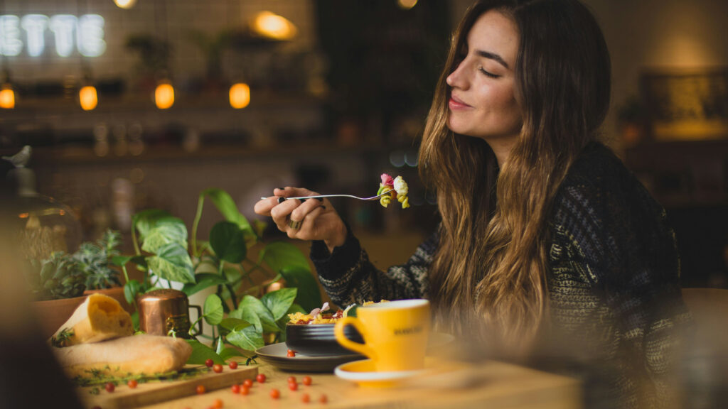 Woman eating. Image courtesy of Unsplash.com. https://unsplash.com/photos/woman-holding-fork-in-front-table-Orz90t6o0e4