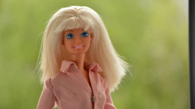 A Barbie doll. This is the featured image for the article on Barbie. Image courtesy of Unsplash.com. https://unsplash.com/photos/blonde-haired-doll-in-pink-coat-OwFURNr9NW0