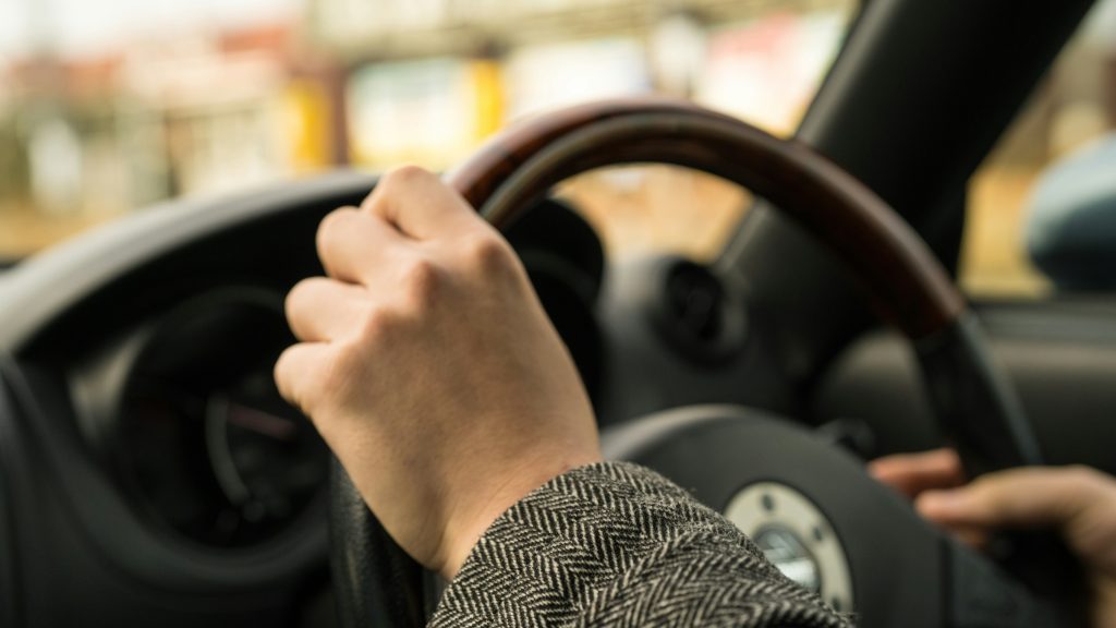 Hands on a steering wheel. Image courtesy of Unsplash.com. https://unsplash.com/photos/person-in-black-and-white-long-sleeve-shirt-driving-car-agXPGYUu1bQ