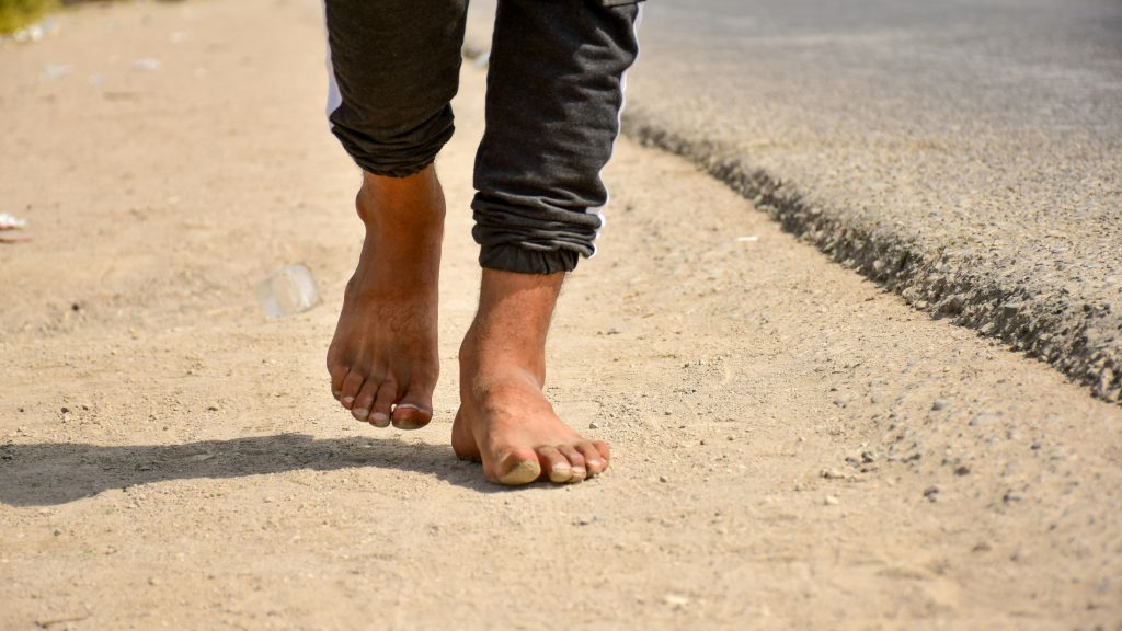 A man walking barefoot. Image courtesy of Unsplash.com. https://unsplash.com/photos/person-in-black-denim-jeans-standing-on-gray-concrete-floor-during-daytime-jJkbc9nWTxA
