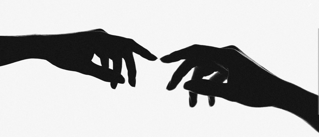 Silhouetted hands almost touching. Photo courtesy of Unsplash.com