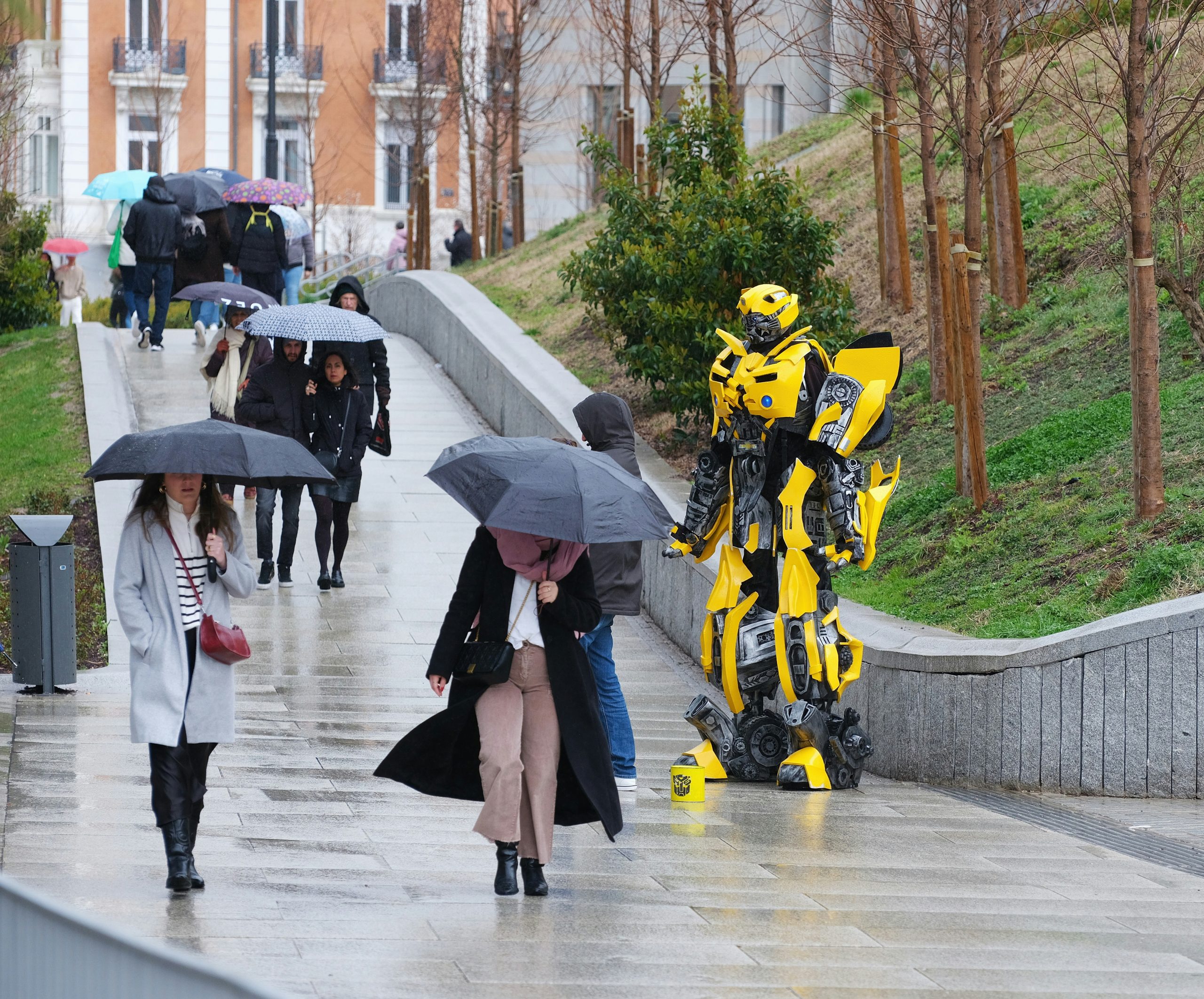 Transformer in the rain. Photo by Dmitrii Eliuseev on Unsplash. https://unsplash.com/photos/a-group-of-people-walking-down-a-sidewalk-holding-umbrellas-MScmjafKMDU