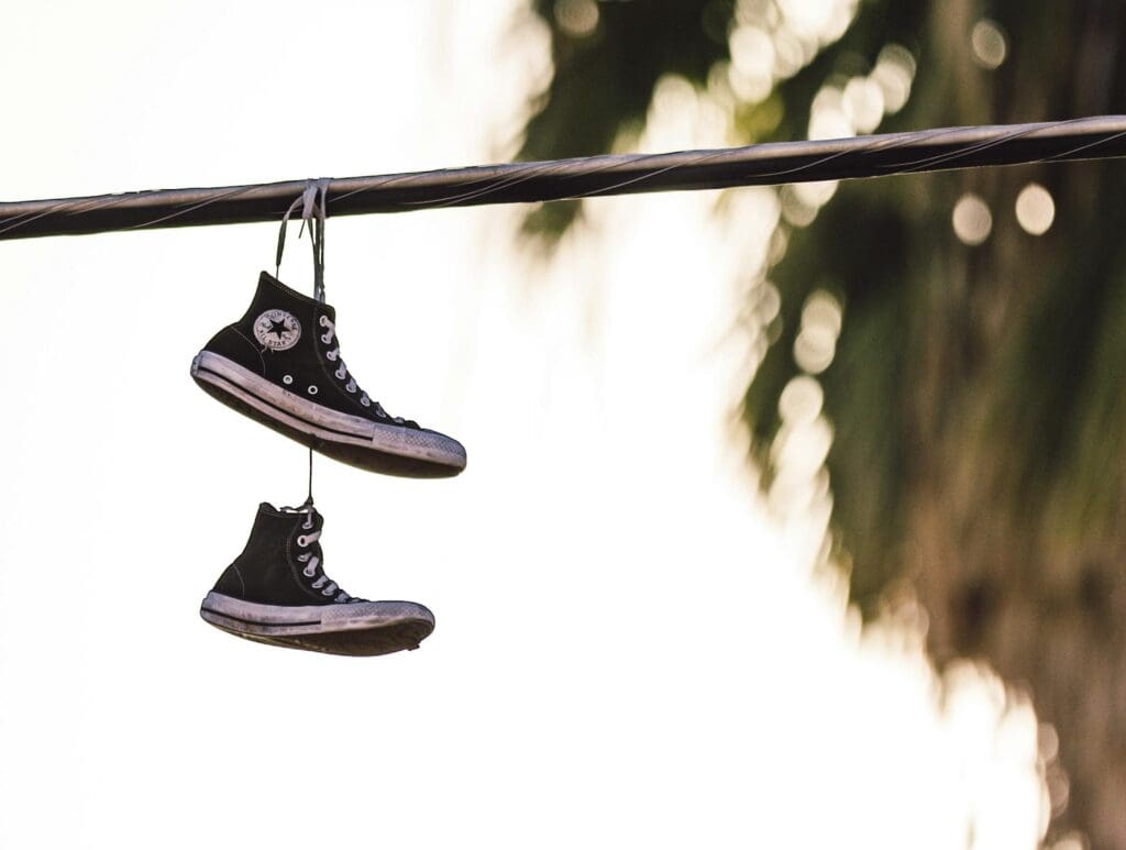 Photo by Sides Imagery: https://www.pexels.com/photo/hanged-pair-of-black-and-white-converse-all-star-sneakers-3110664/
