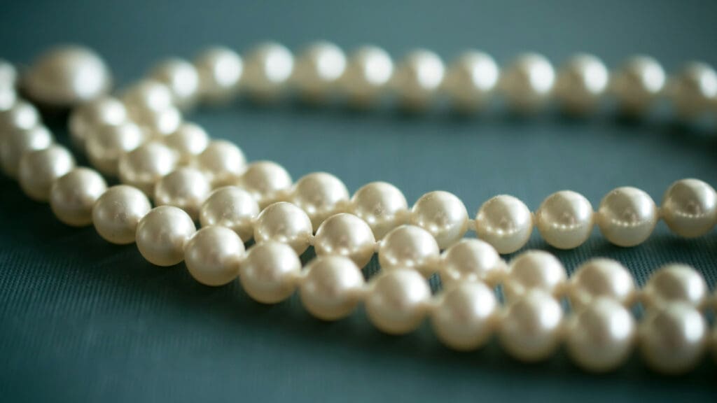 A pearl necklace. Image courtesy of Unsplash.com. https://unsplash.com/photos/white-pearl-necklace-on-gray-textile-09bKHOZ29us