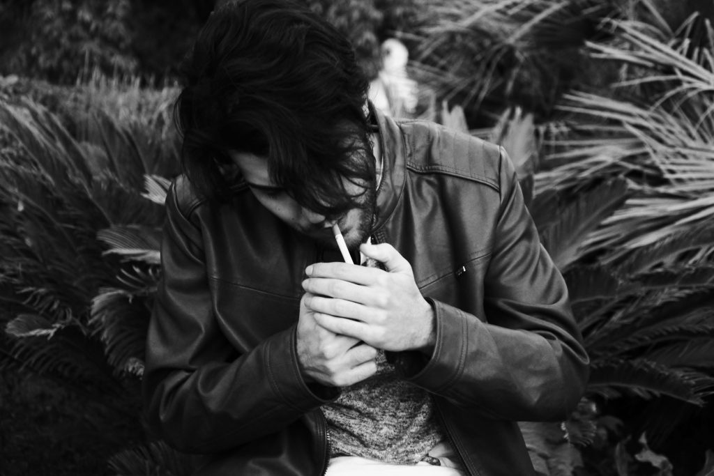 A person smoking. Photo by Andrea Dibitonto on Unsplash. https://unsplash.com/photos/grayscale-photo-of-man-holding-lighter-CFu7TroYt3o