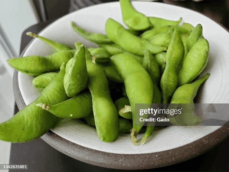 A bowl of edamame, immature green soybeans still inside their pods.