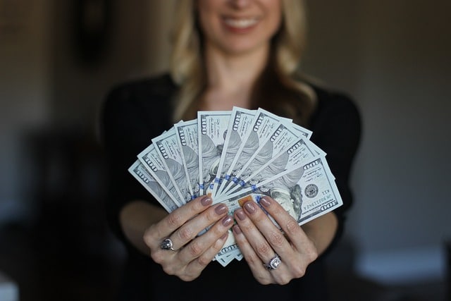 Zodiac Signs - Picture of a woman holding some dollar bills