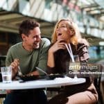 Happy young couple laughing while having lunch at a food court- Relationship myths