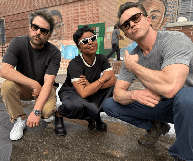 Rob McElhenney, Charlie Day, and Quinta Brunson posing on the "Abbott Elementary" set.