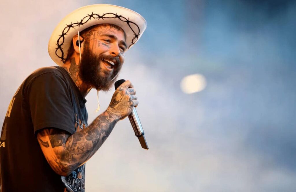 Post Malone performing on stage in a cowboy hat, a top streaming artist on Apple Music.