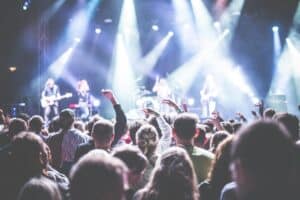 Energetic concert scene with a vibrant audience and band performing under bright lights. Ohana Festival 2025