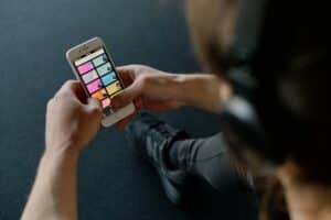 Close-up of a person listening to music on a smartphone while at the gym, focusing on a streaming playlist app, Spotify. Top 10 Streaming Artists on Spotify