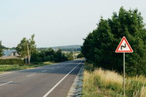 A red and white sign sitting on the side of the road. Detour Travel