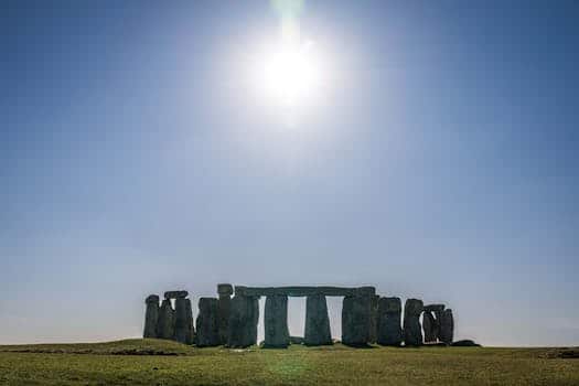 Stonehenge silhouette under a bright midday sun, showcasing iconic ancient structure. Litha