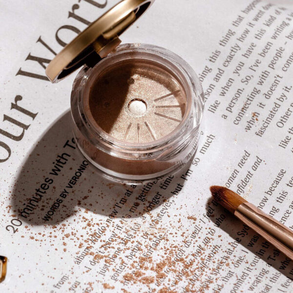 Close-up of a gold glitter eyeliner makeup brush applying sparkling gold powder, showcasing cosmetics and fashion beauty tools—perfect for beauty travel essentials. Image credit: AdoreBeautyNZ via Pixabay.
