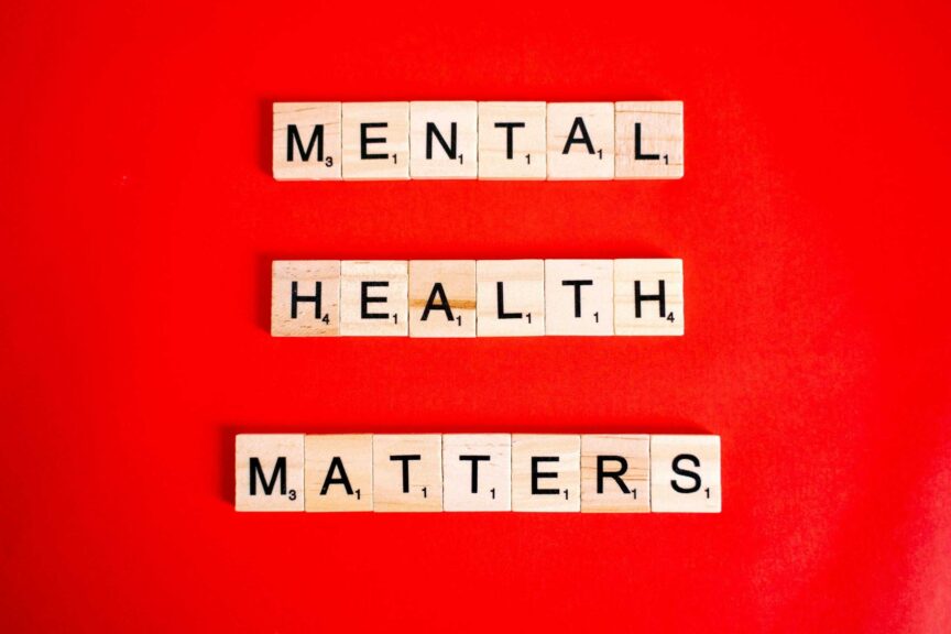 Wooden tiles spelling 'Mental Health Matters' on a vivid red background.