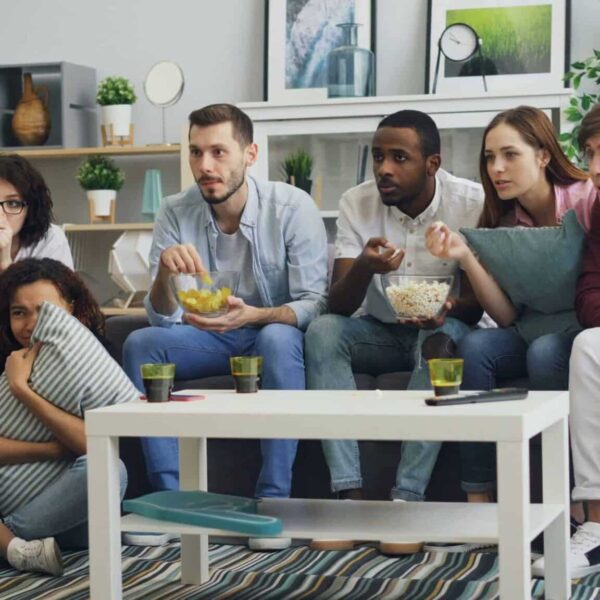 a group of people sitting on a couch in a living room / TV ratings