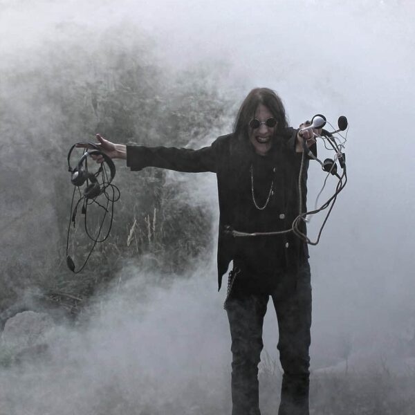 Ozzy Osbourne surrounded by smoke, holding cables with a chaotic grin — a visual that captures the rock legend’s wild energy and hints at his unpredictable food favorites.