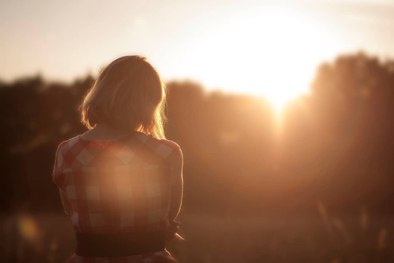 This is a photo of a woman watching a sunset. It demonstrates how taking alone time within a relationship can work.