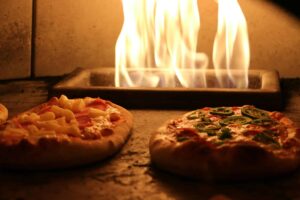 Delicious pizzas with various toppings cooked in a traditional wood-fired oven. Frozen pizza