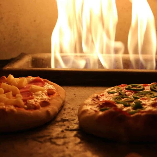 Delicious pizzas with various toppings cooked in a traditional wood-fired oven. Frozen pizza