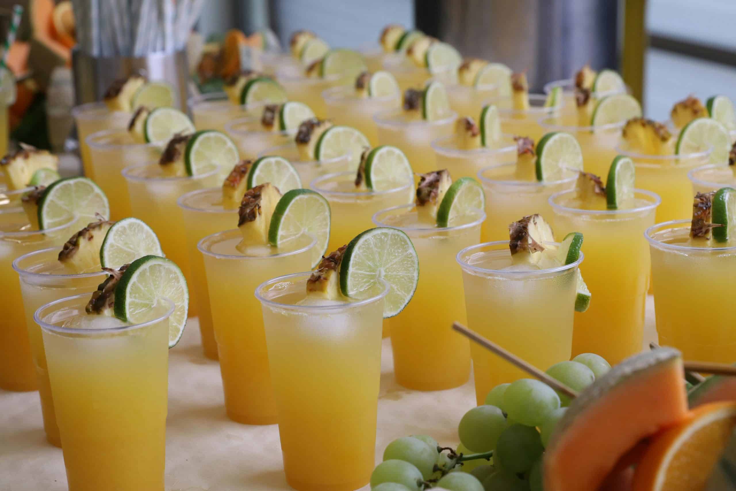 Refreshing tropical drinks with lime and pineapple garnishes in an inviting setting.
