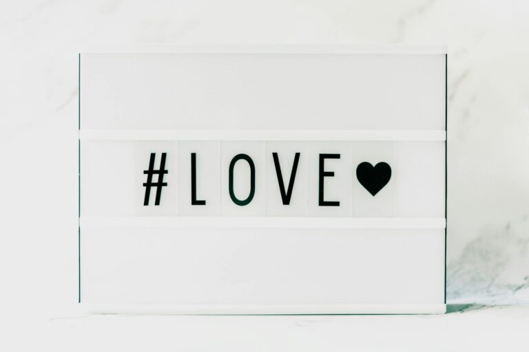 Contemporary minimalist sign displaying '#LOVE' in text with a black heart on a white background. venus in leo, love, bold love, emotional shifts,