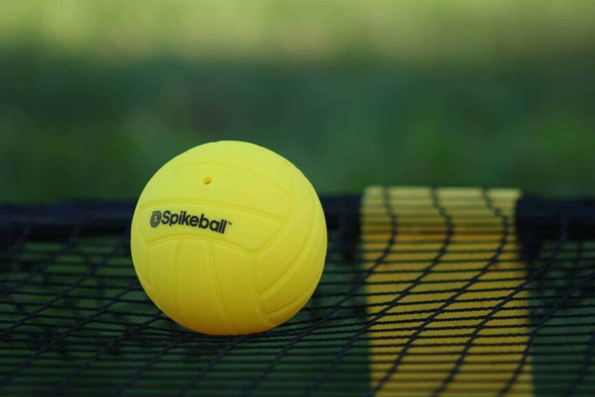 This photograph features a net and ball used in Spikeball. Spikeball and other lawn games can be fun at backyard parties.