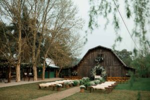 wedding arch, Rustic barn decorated for an outdoor wedding ceremony with floral arrangements.