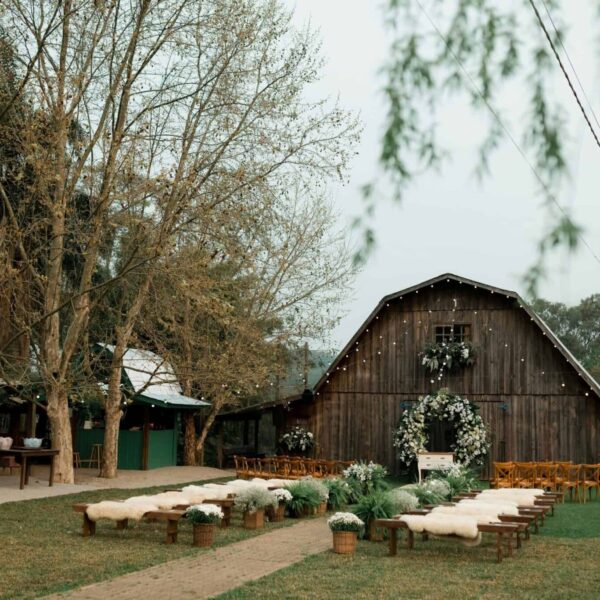 wedding arch, Rustic barn decorated for an outdoor wedding ceremony with floral arrangements.