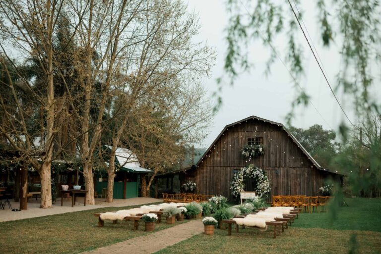 wedding arch, Rustic barn decorated for an outdoor wedding ceremony with floral arrangements.