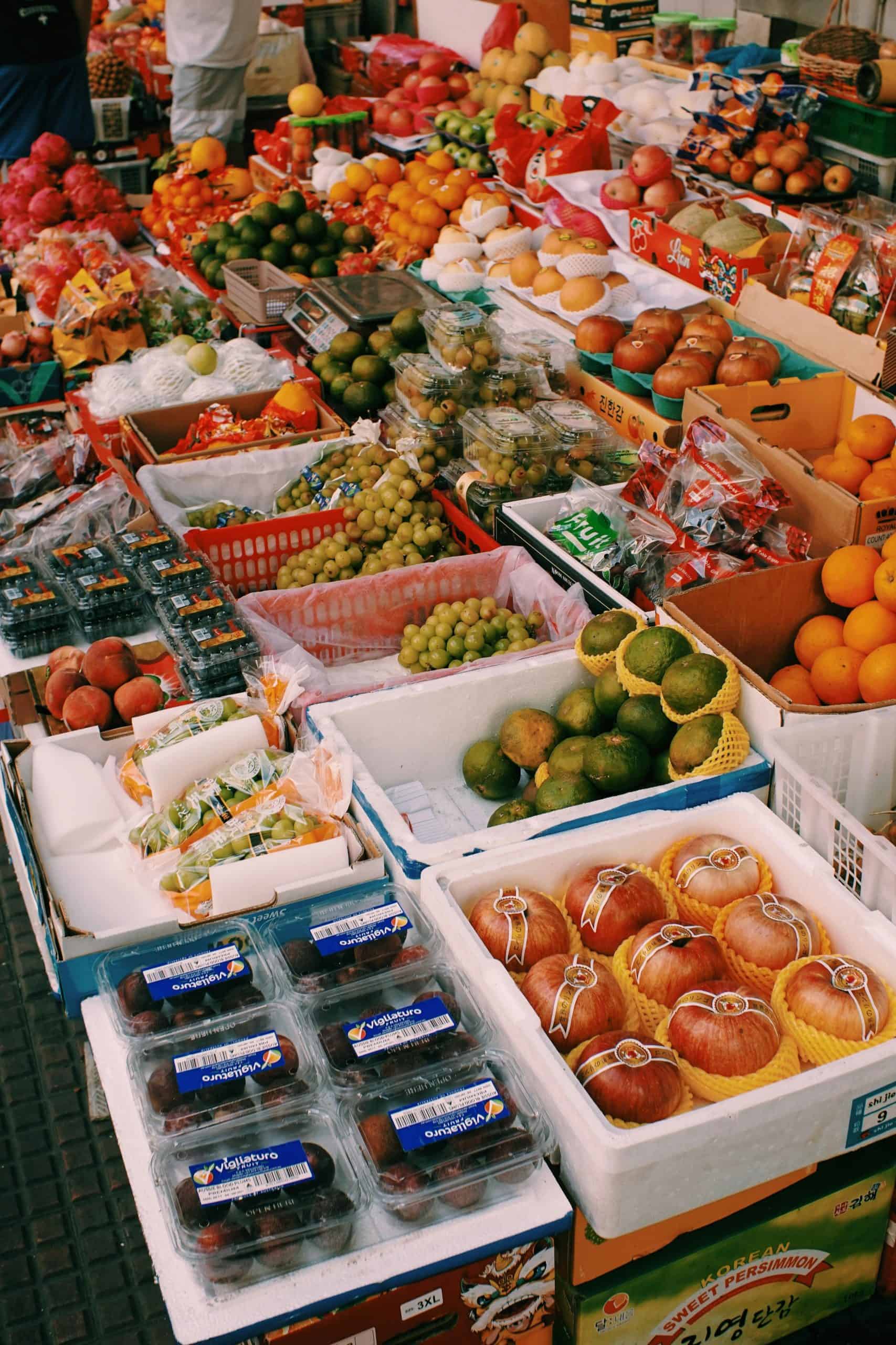 Colorful outdoor market stall with diverse fresh fruits on display, vibrant and inviting. 