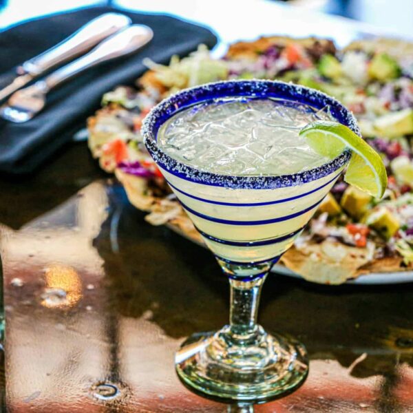 Close-up of a margarita with lime garnish on a restaurant table, perfect for a festive occasion. 3-ingredient drinks
