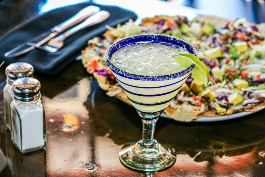 Close-up of a margarita with lime garnish on a restaurant table, perfect for a festive occasion. 3-ingredient drinks