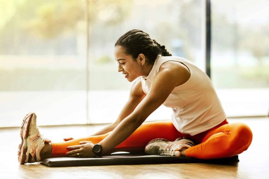 A woman enjoying a yoga stretch indoors, promoting a healthy lifestyle. stretching