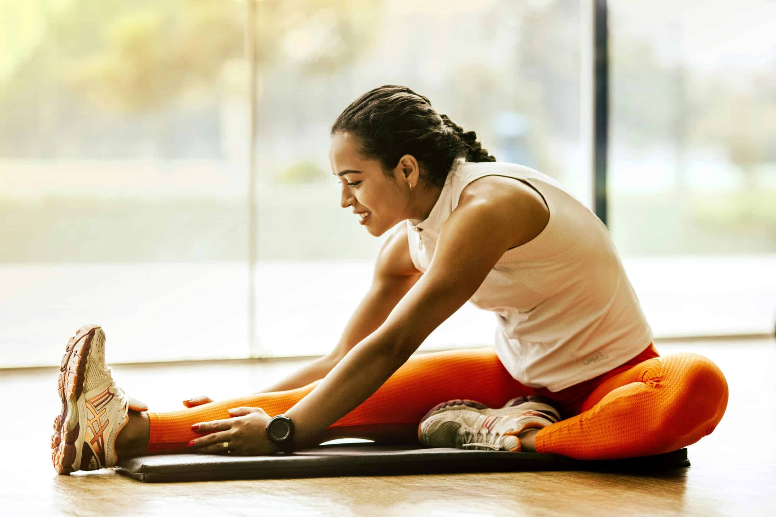 A woman enjoying a yoga stretch indoors, promoting a healthy lifestyle. stretching