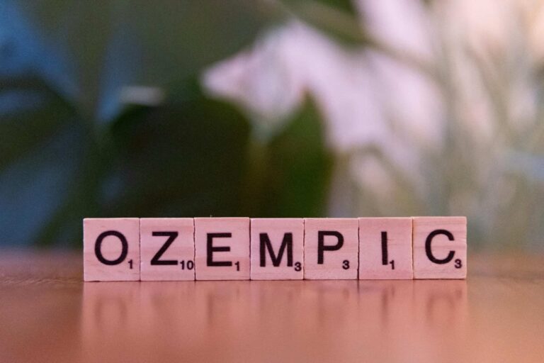 Scrabble tiles spelling 'Ozempic' on a wooden surface, healthcare theme.