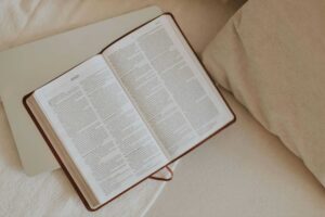 Daily Devotion. An open Bible on a beige blanket, inviting peaceful reflection and spiritual reading.