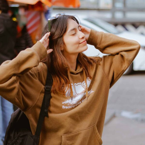Woman in a brown hoodie enjoying a peaceful sunny day outdoors, reflecting on self-care and assessment. Photo by César O'neill via Pexels.