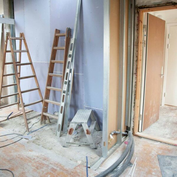 Construction site featuring ladders and tools in a home renovation setting.