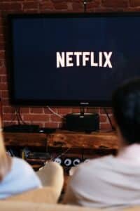 A couple relaxing and watching Netflix in a cozy living room setting.