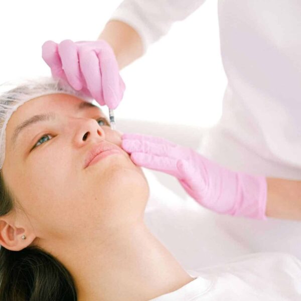 Woman receives cosmetic injection in clinical setting, enhancing beauty using modern techniques. microdosing filler