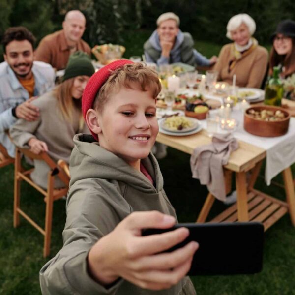 generational differences, families, Cheerful family taking a selfie during an outdoor garden dinner party.
