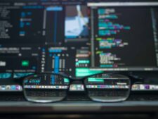 Eyeglasses reflecting computer code on a monitor, ideal for technology and programming themes. AI/ google