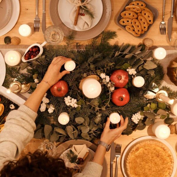 A top-down view of a festive holiday table setting with candles and decorations, perfect for Christmas or New Year's dinner. Family traditions