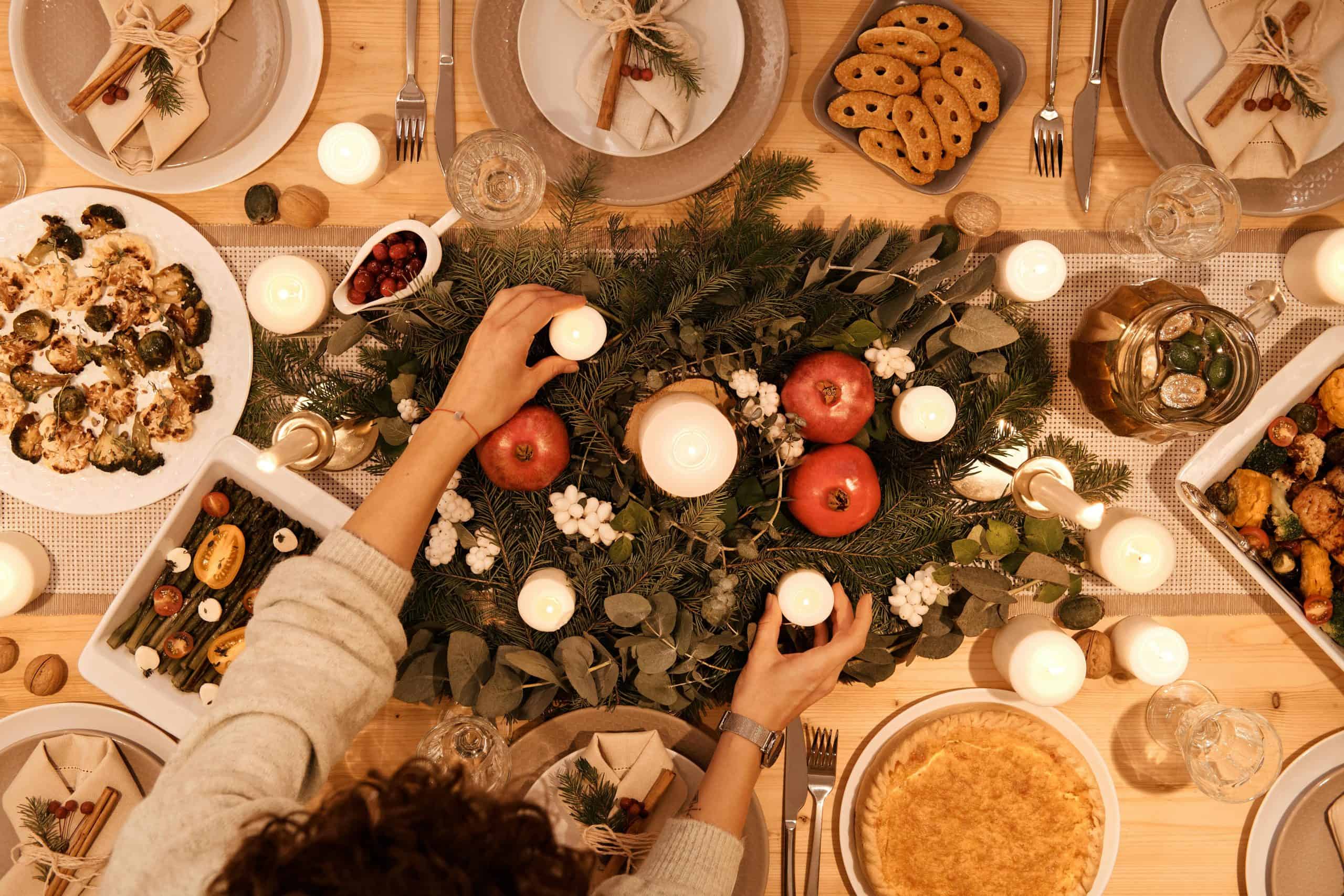 A top-down view of a festive holiday table setting with candles and decorations, perfect for Christmas or New Year's dinner. Family traditions