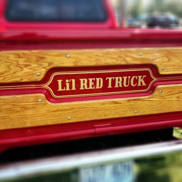 tailgate,Close-up of a vintage Li'l Red Truck showcasing retro design and wooden panels.