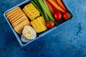 A vibrant lunchbox filled with nutritious vegetables, eggs, and crackers for a healthy meal. Lunchbox wellness