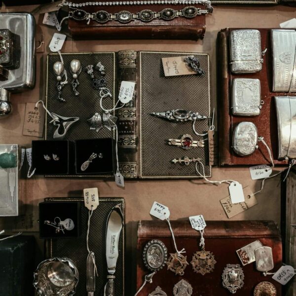 A curated selection of vintage and antique items on a display, including jewelry, books, and decorative pieces. antique shops