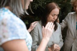 Three women in a heartfelt prayer gathering, emphasizing faith and community. praying with others